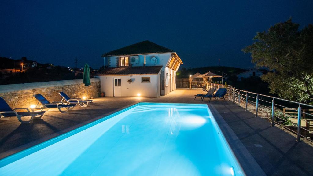 una piscina frente a una casa por la noche en Quinta do Esteval, en Penacova