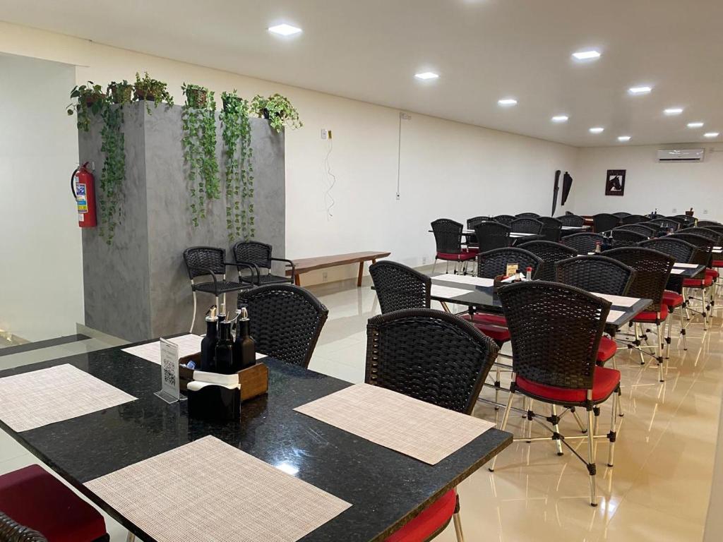 an empty room with tables and chairs in a classroom at Hotel Itamaraty in Várzea Grande