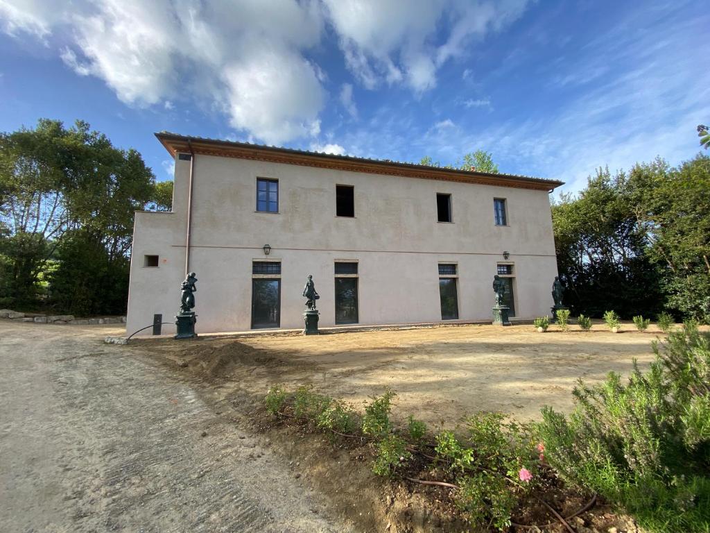 Un grand bâtiment blanc avec de nombreuses fenêtres dans l'établissement Villa Cosmiana: the gate house apartment, à Peccioli