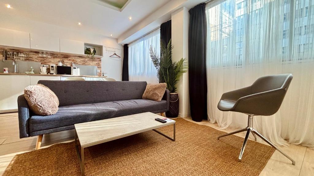 ein Wohnzimmer mit einem Sofa und einem Stuhl in der Unterkunft ☆Loft 35m2 Lyon 6 Ménage inclus/pas de check out☆ in Lyon