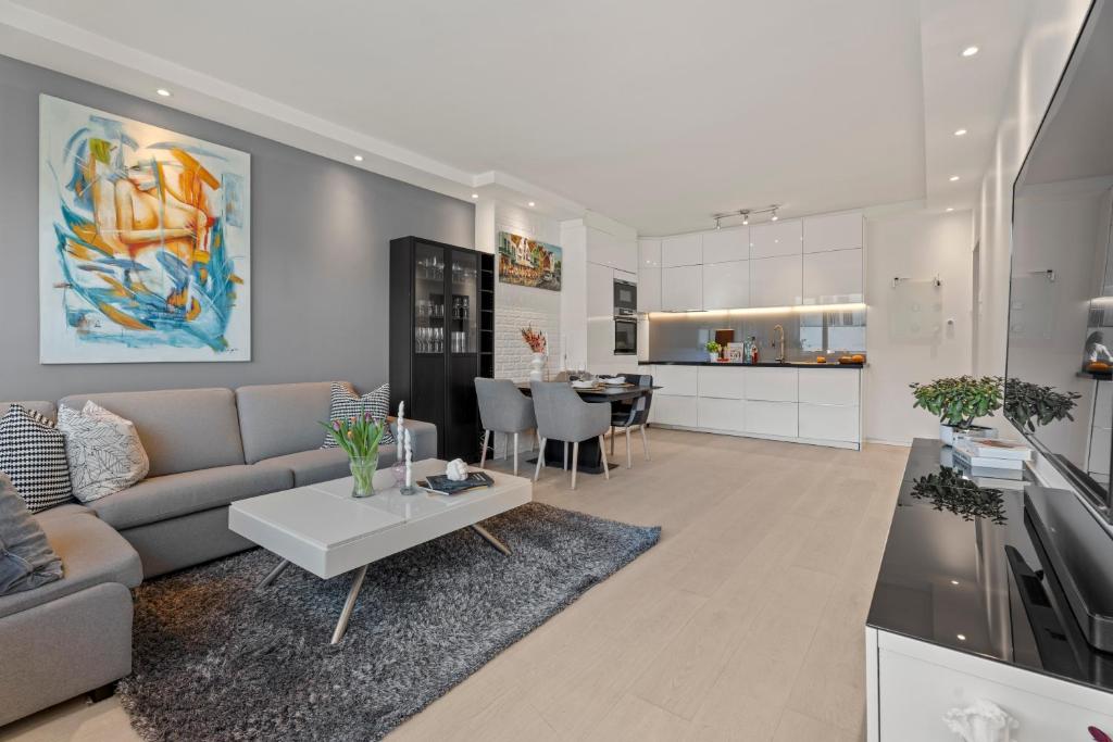 a living room and kitchen with a couch and a table at Central Oslo - Lovely 2 bedrooms flat with balcony in Oslo