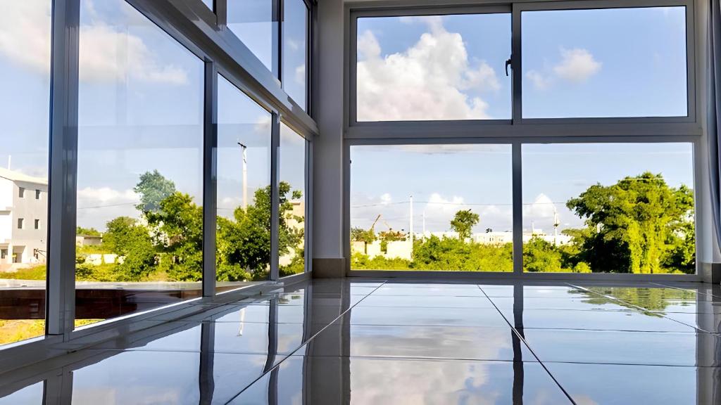 an empty room with windows and a view of trees at Villa Sian in Punta Cana