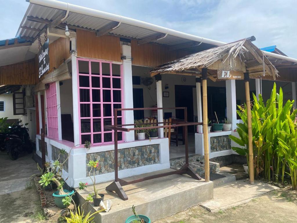 une petite maison avec une porte rose dans l'établissement EL Homestay Bunaken, à Bunaken