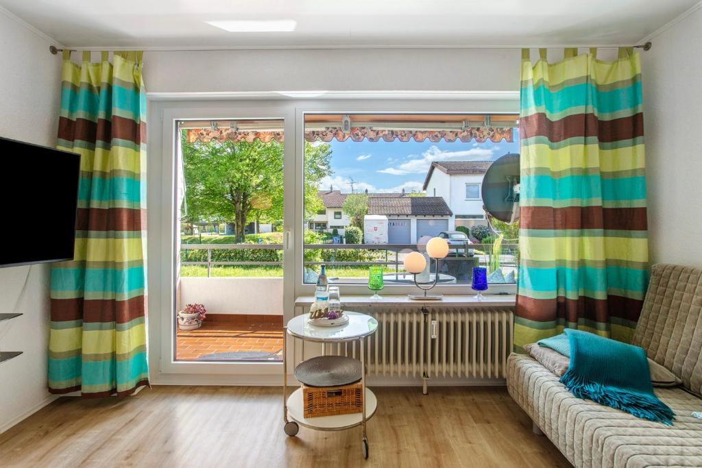 a living room with a couch and a large window at Ferienappartement Magjar in Küssaberg