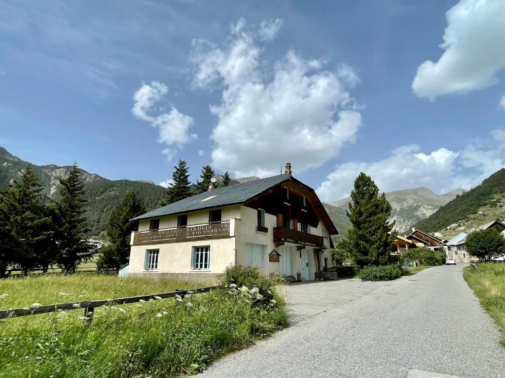 une maison assise sur le côté d'une route dans l'établissement Gîte montagne 1 à 25 places "Chalet Coste Belle", à Ceillac