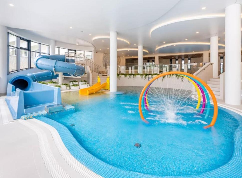 a large indoor water park with a water slide at Aquapark&Sea Apartament Aquapolanki in Kołobrzeg