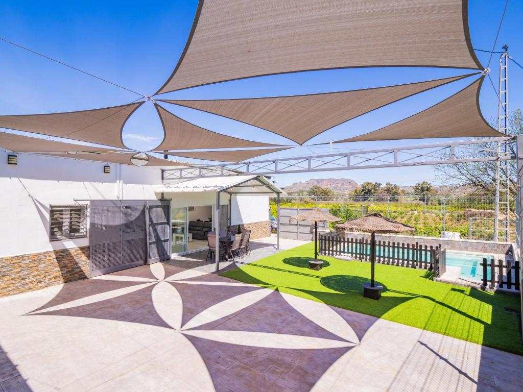 a large umbrella on a patio with a pool at Cubo's Casa Rural Maylu in Villafranco de Guadalhorce