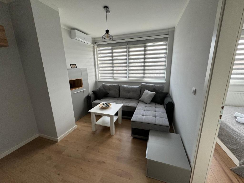 a small living room with a couch and a table at XL Apartman in Teslić