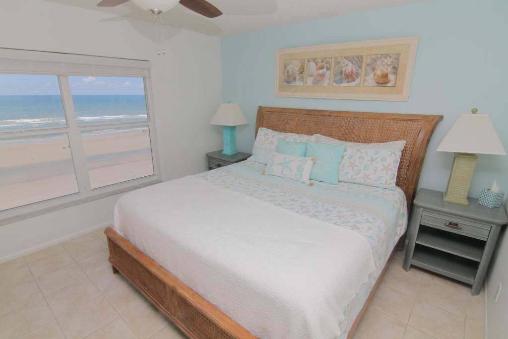 1 dormitorio con 1 cama y vistas al océano en Direct Oceanfront Condo, No-Drive Beach, Great Beach View From Private Balcony, en New Smyrna Beach