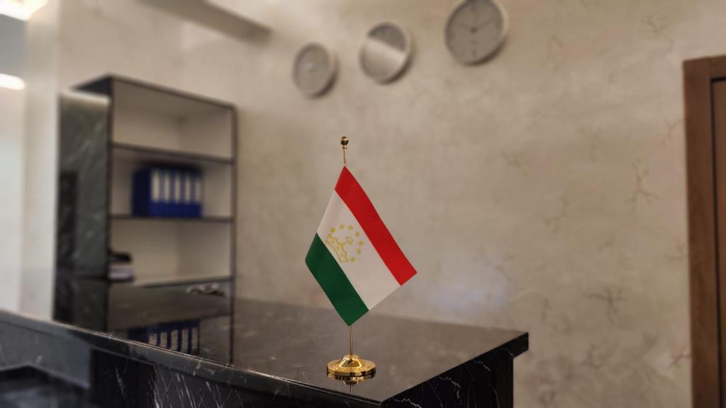 a flag on a counter in a room with clocks at Calipso Dushanbe Hotel in Dushanbe