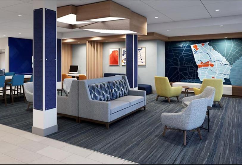 a lobby with a couch and chairs and tables at Holiday Inn Express & Suites Austin Airport East, an IHG Hotel in Austin