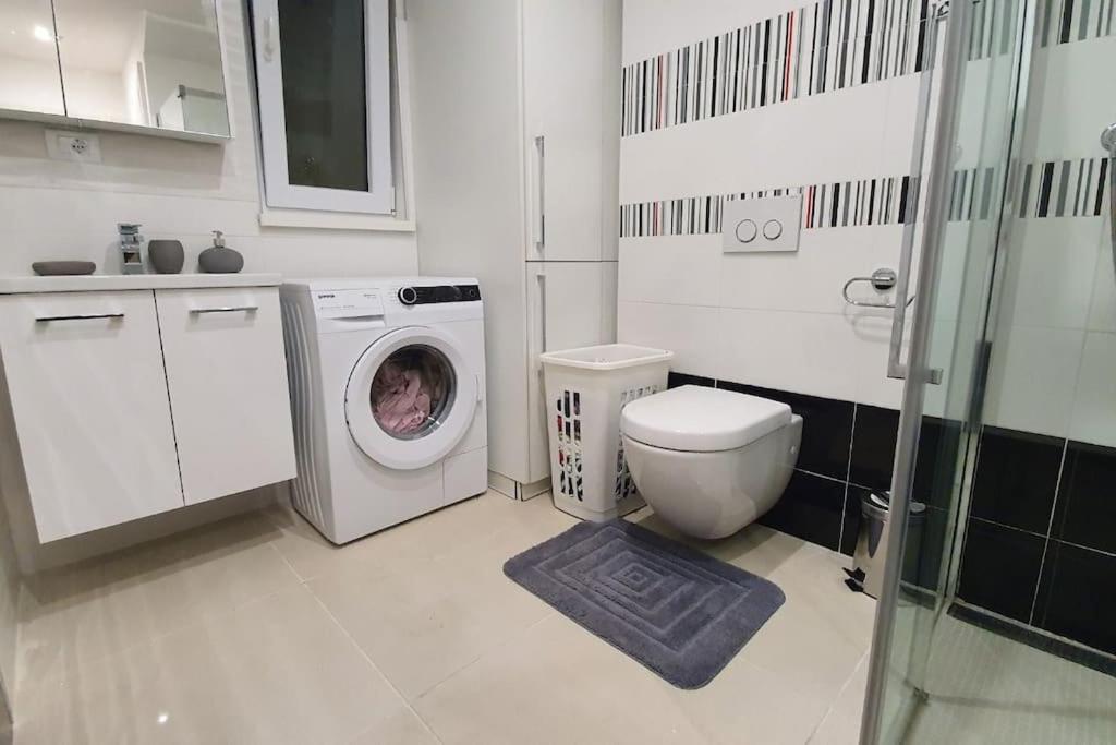 een badkamer met een wasmachine en een toilet bij Apartment with Sea View and jacuzzi in Koper