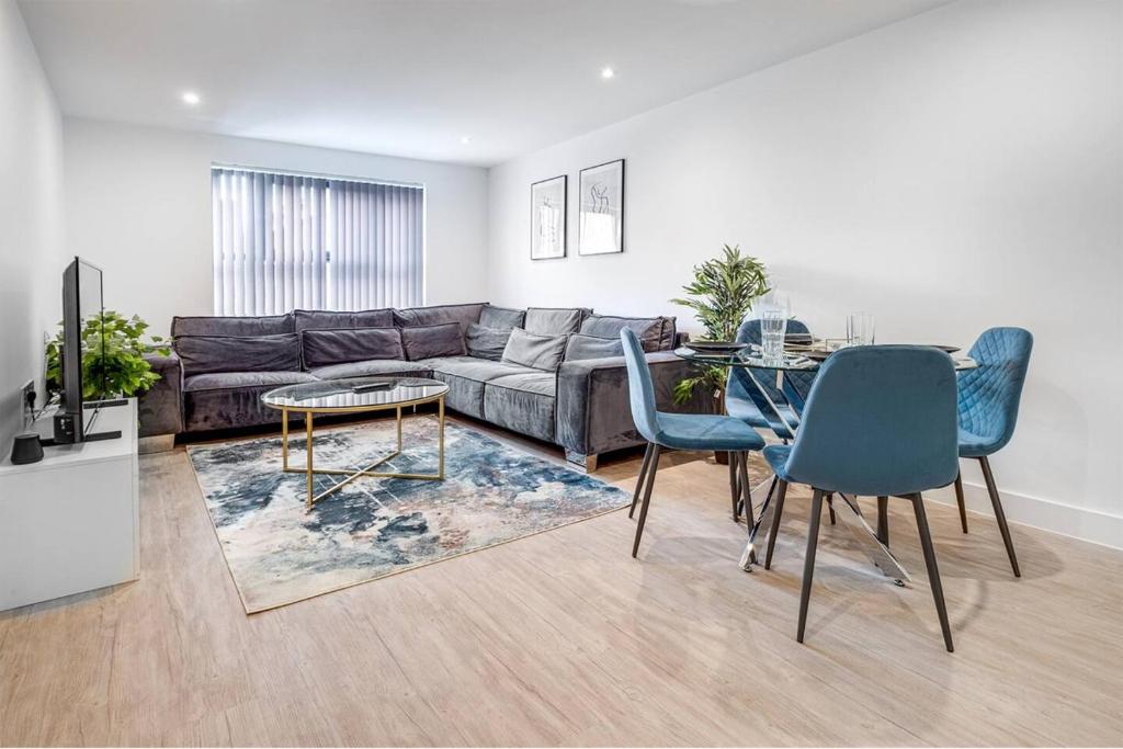 Una sala de estar con un sofá, una mesa y sillas. en Digbeth Luxury Apartment, en Birmingham