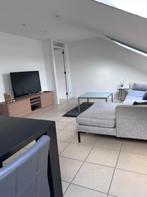 un soggiorno con un divano e una TV di Studio 177 a Waregem