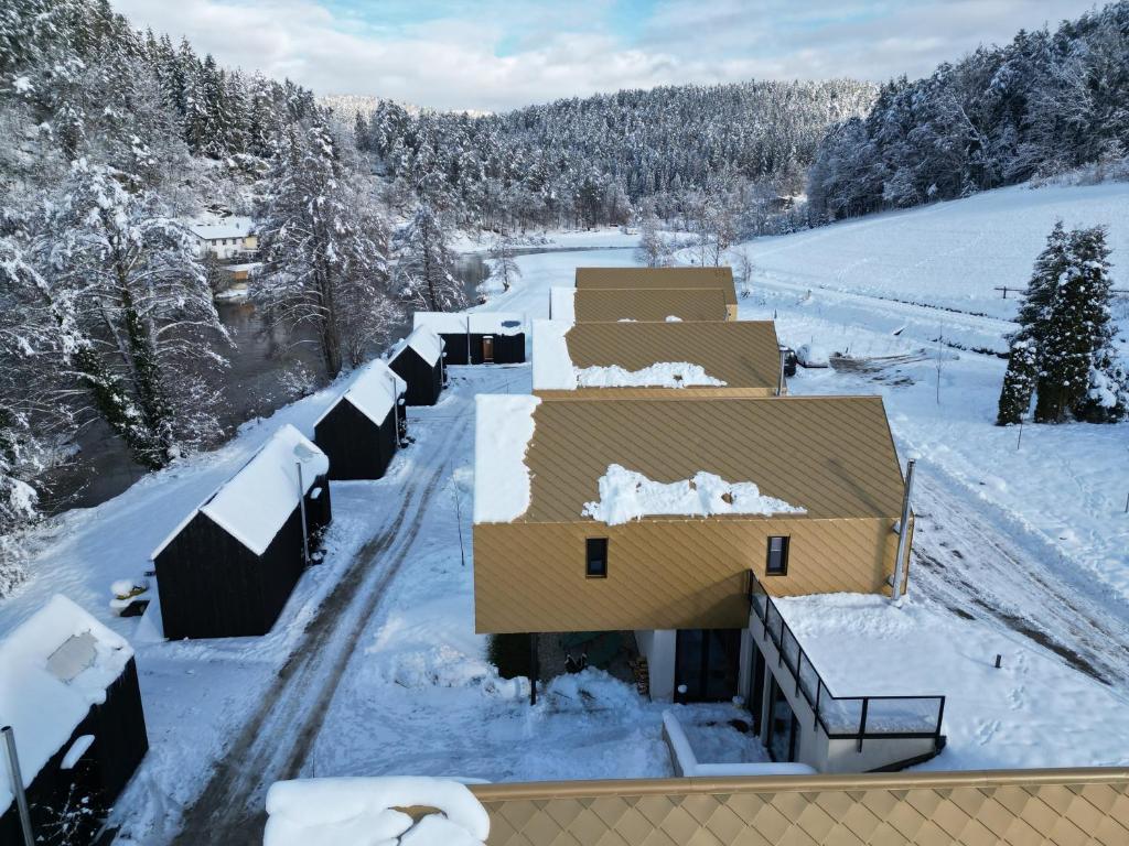 a house covered in snow with snow on the roof at Adventure Camp Schnitzmühle in Viechtach