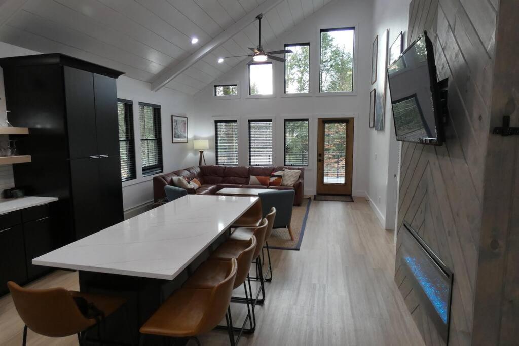 cocina y sala de estar con mesa y sillas en Modern Chalet with Hot Tub and Lake Access, en Monticello