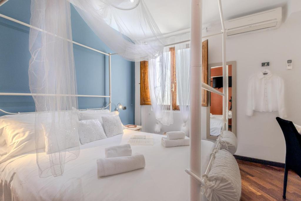 1 dormitorio con cama blanca y almohadas blancas en Il Panoramico Rooms, en Cagliari