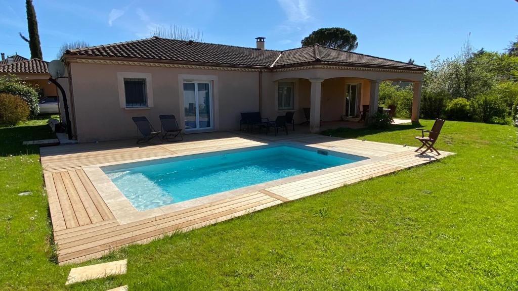 um quintal com uma piscina e uma casa em Villa spacieuse avec piscine privé , Vallée du Lot em Prayssac