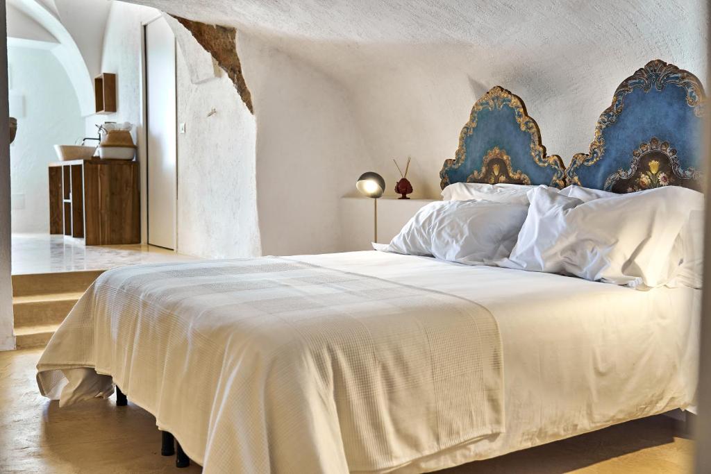 a bedroom with a large white bed with a blue headboard at Il Trappetello in Monopoli