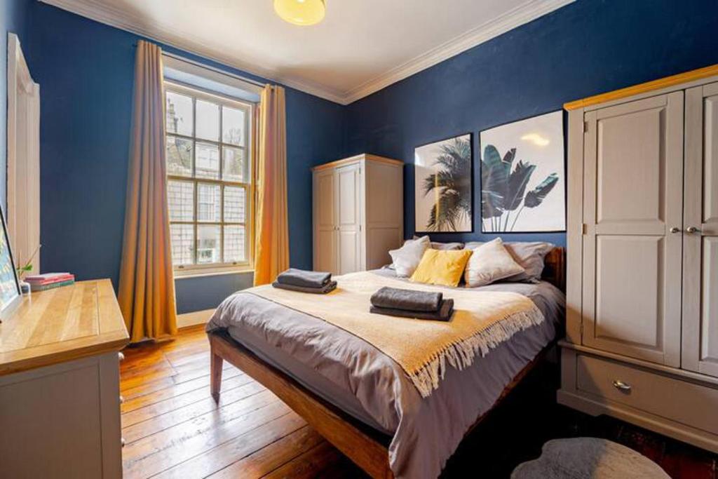 um quarto com uma cama grande e paredes azuis em Spacious 1-Bed City Centre Apartment in Aberdeen em Aberdeen