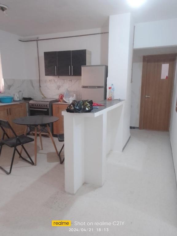 a kitchen with a counter and a table in a room at F3 belle vue in 'Aïn Benian
