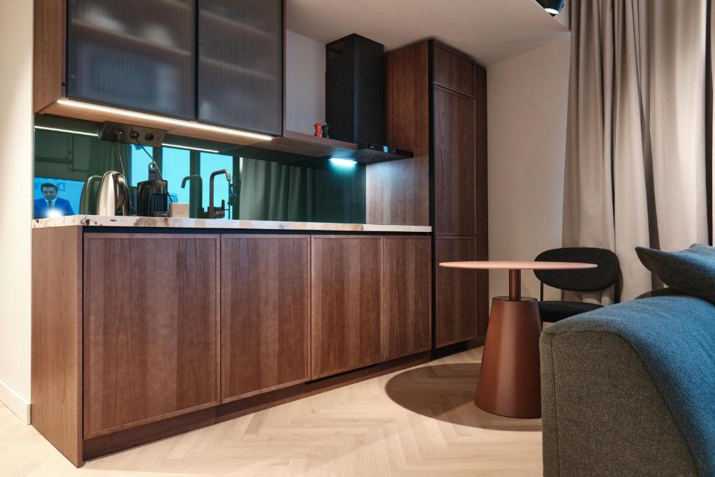 a kitchen with wooden cabinets and a table in a room at The Zipper Hotel und Apartments in Düsseldorf