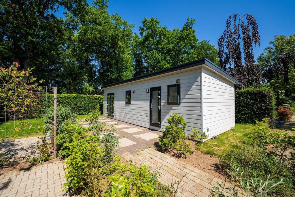 een klein wit tiny house in een tuin bij Gezellig modern chalet midden op de Veluwe in Epe