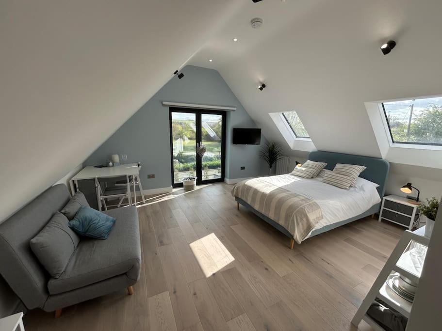 1 dormitorio con 1 cama y 1 sofá en el ático en The Nest en Uffington
