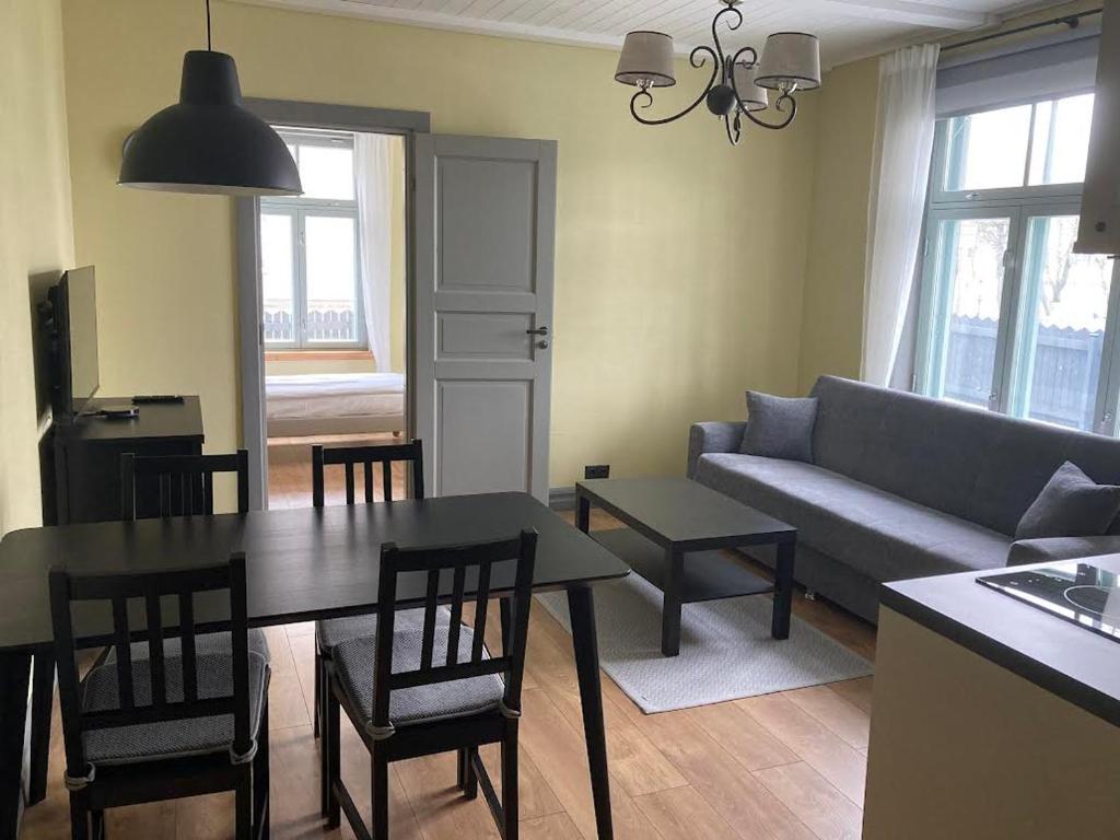 a living room with a couch and a table and chairs at Tiigi Apartment in Paide