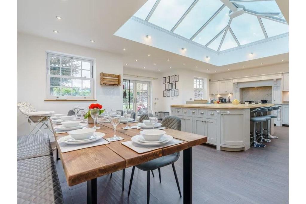 a dining room and kitchen with a table and chairs at luxury Farmhouse: Hot Tub & Garden in Soutergate