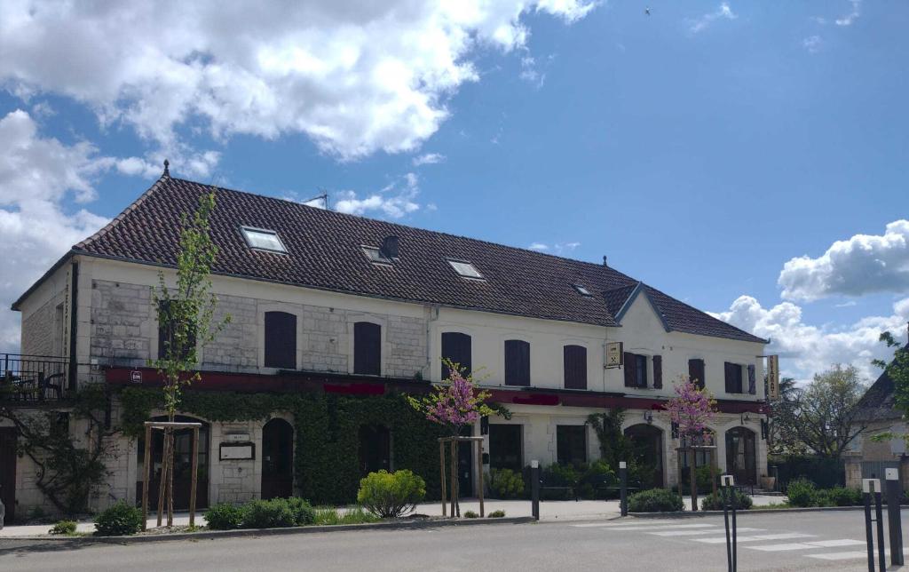 un grand bâtiment blanc avec un toit noir dans l'établissement Auberge d'ici et d'ailleurs, à Cressensac