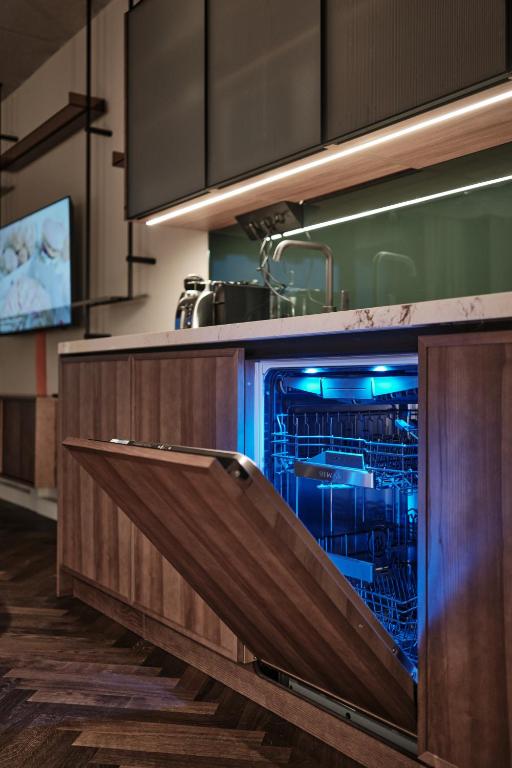a kitchen with an open dishwasher in a kitchen at The Zipper Hotel und Apartments in Düsseldorf