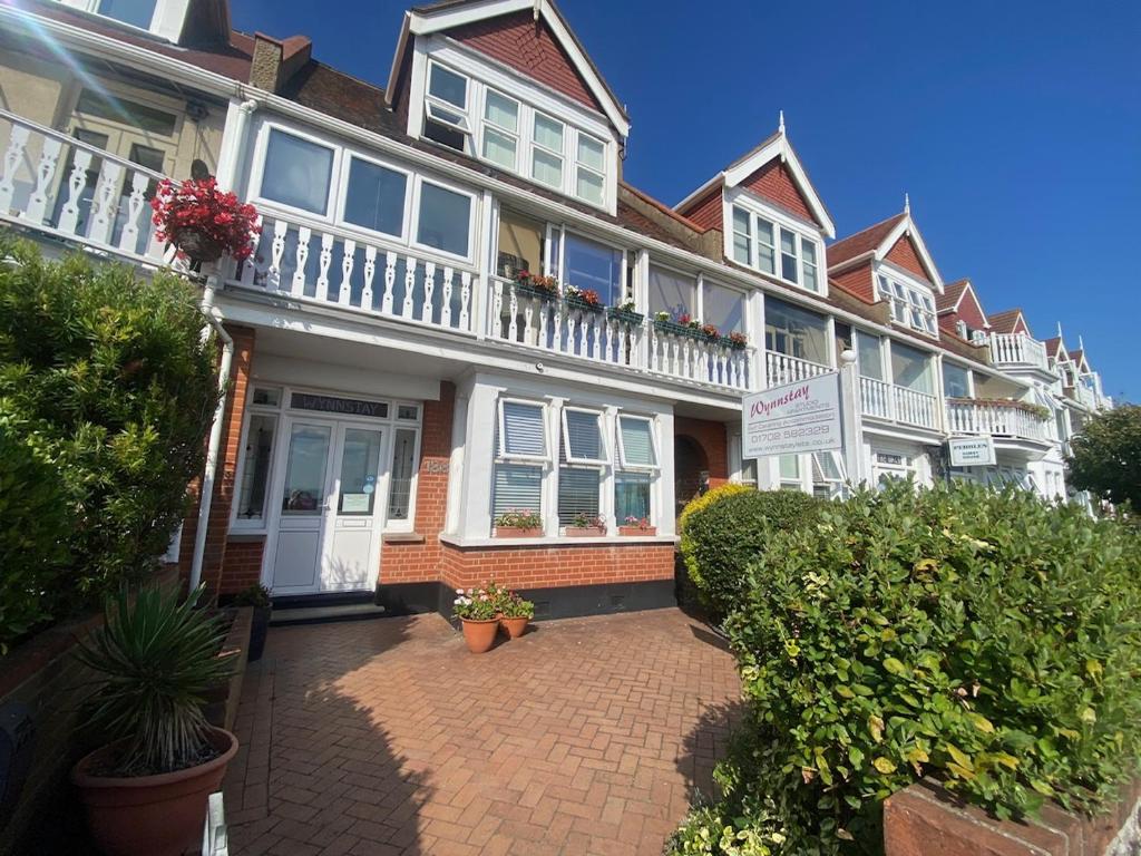 a large white house with a balcony and plants at WynnStay Studio Apartments in Southend-on-Sea