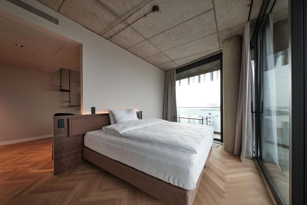 a bedroom with a large bed and a large window at The Zipper Hotel und Apartments in Düsseldorf