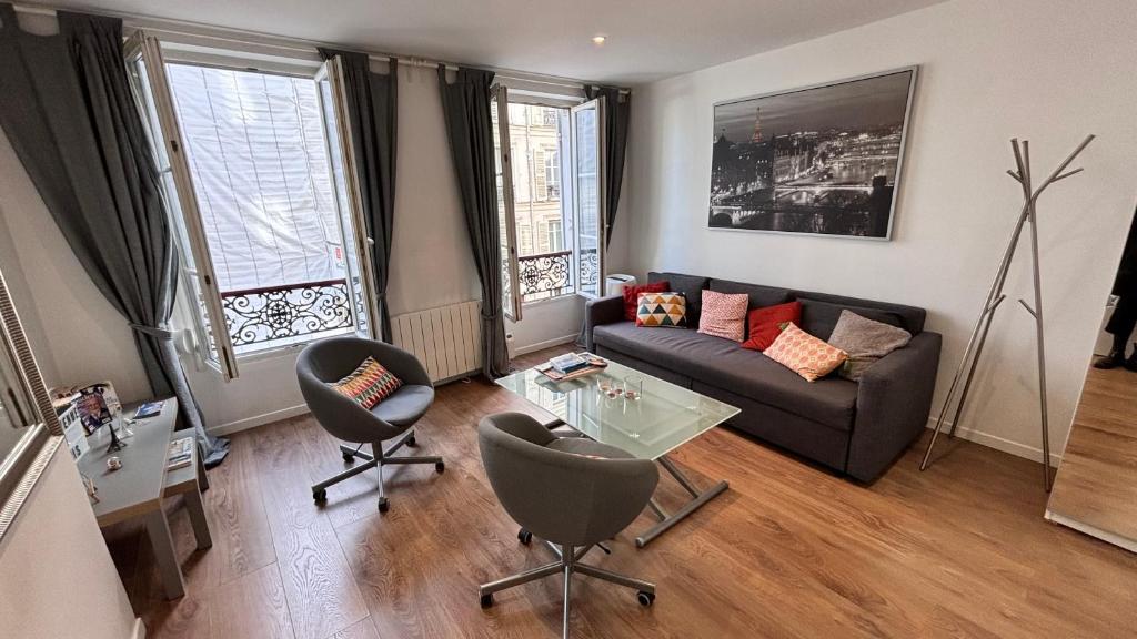 un salon avec un canapé et une table dans l'établissement Charmant apartment in Monmartre, à Paris