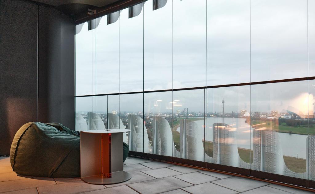 a room with a table and a view of a city at The Zipper Hotel und Apartments in Düsseldorf
