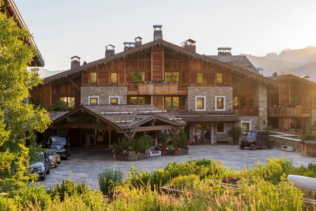 um grande edifício com carros estacionados num parque de estacionamento em Four Seasons Hotel Megeve em Megève