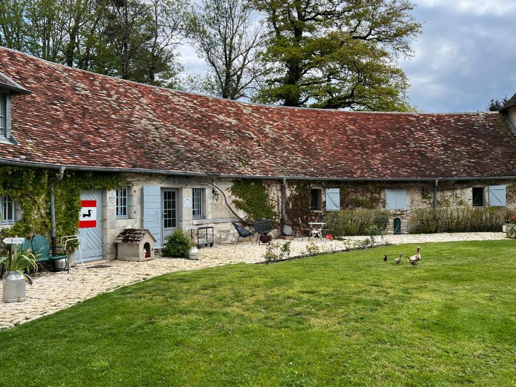 a house with a yard with ducks in front of it at La Forge de Malpas in Quingey