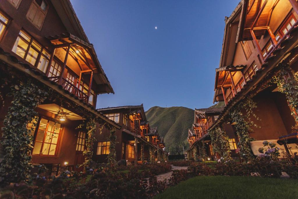 a row of buildings at night with mountains in the background at Kutimuy Lodge in Urubamba