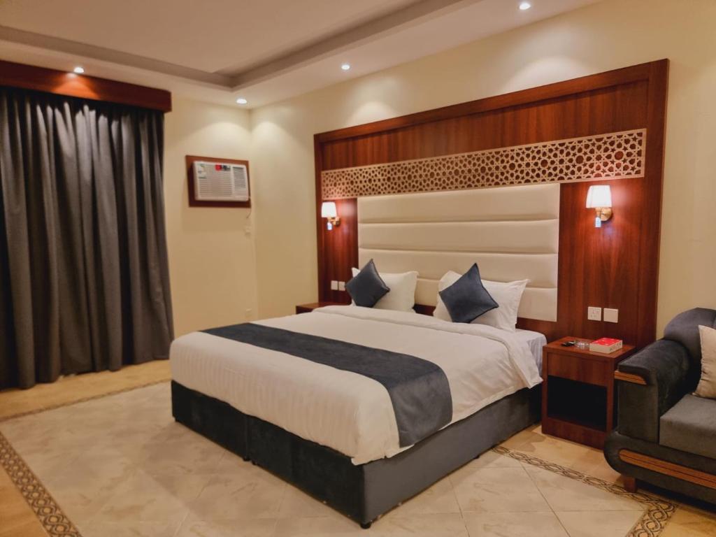 Habitación de hotel con cama y silla en الديار الفاخرة - الربوة en Yeda