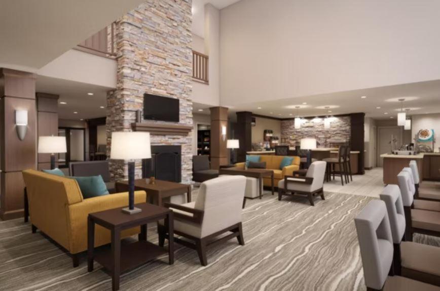 a hotel lobby with couches and chairs and a fireplace at Staybridge Suites Miramar Beach - Sandestin Area, an IHG Hotel in Destin