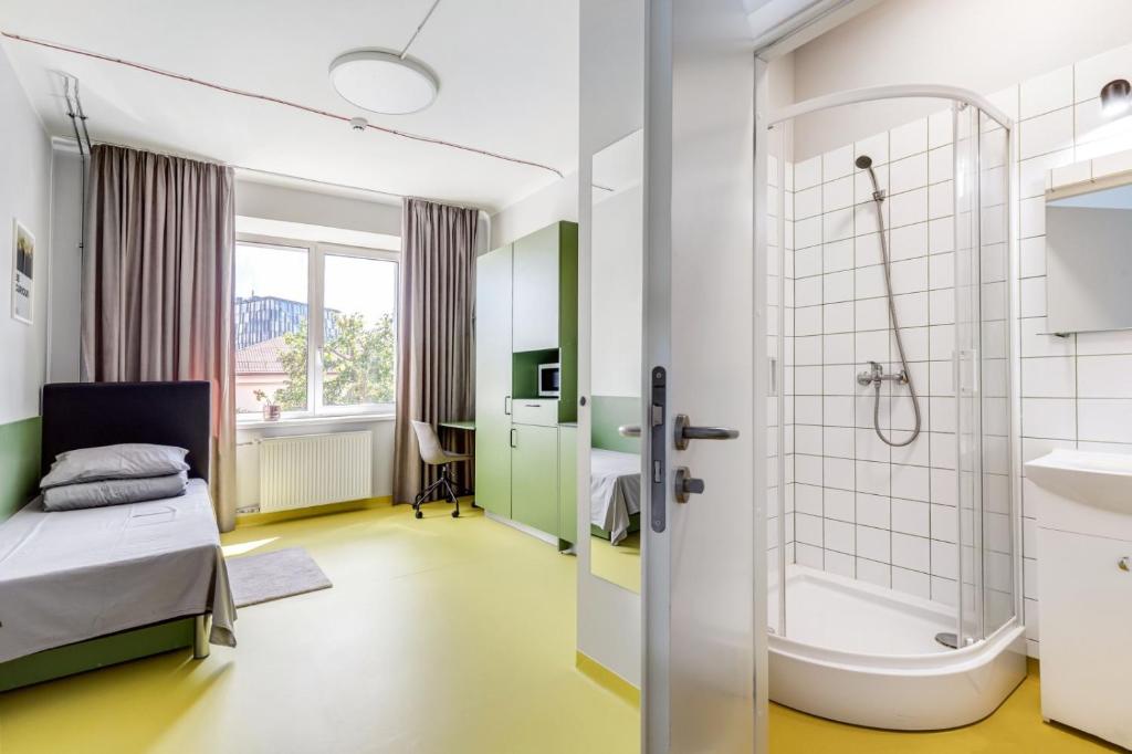 a hospital room with a bed and a bath tub at Solo Society Kaunas Apartments in Kaunas