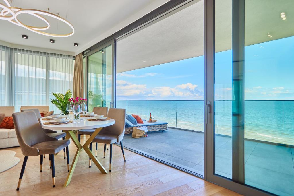 una sala da pranzo con tavolo e vista sull'oceano di Wave Resort&Spa - Top Penthouse a Międzyzdroje