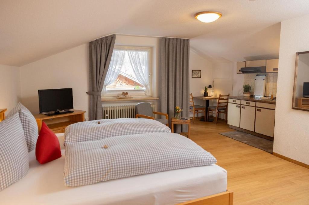 een woonkamer met een bed en een keuken bij Ferienwohnung Rosenwirth - b45171 in Mittenwald