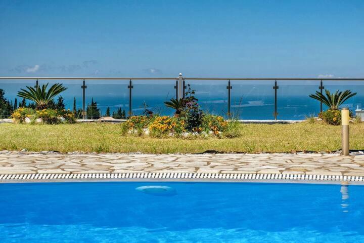 uma piscina azul com vista para o oceano em Goudis Villas em Tsoukaladhes