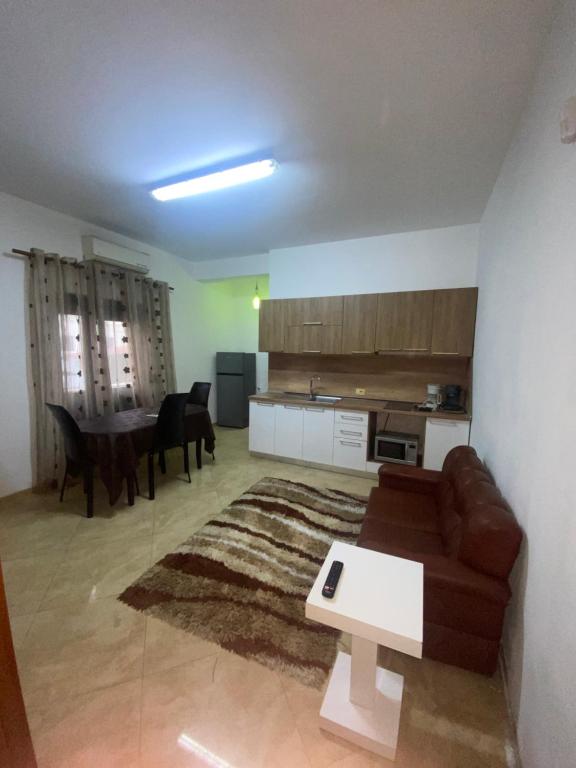 uma sala de estar com um sofá e uma mesa em Henri Apartaments em Durrës