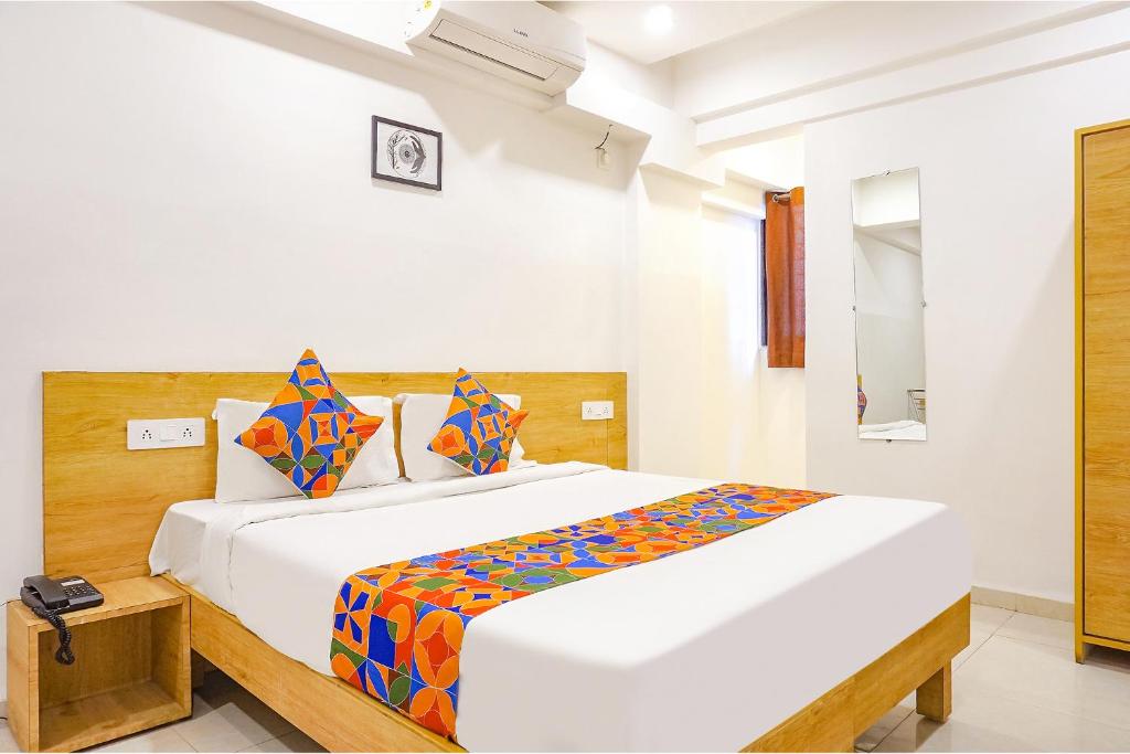 a white bedroom with a large bed in it at FabHotel Saffron Inn I in Pune