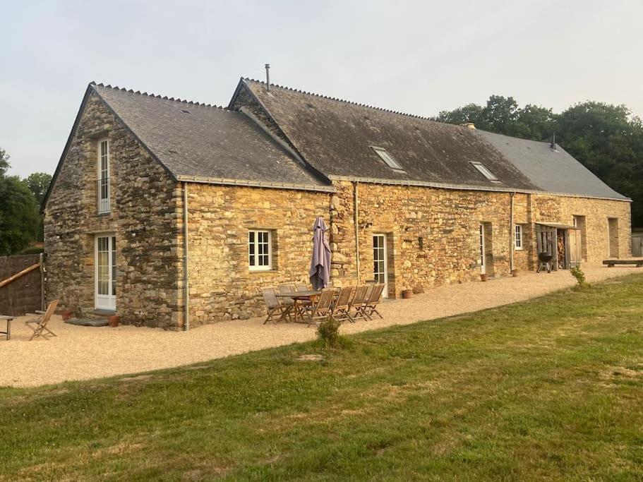 - un bâtiment en pierre avec une table de pique-nique devant dans l'établissement Gîte 11 personnes en pleine campagne, à Sainte-Anne-sur-Vilaine