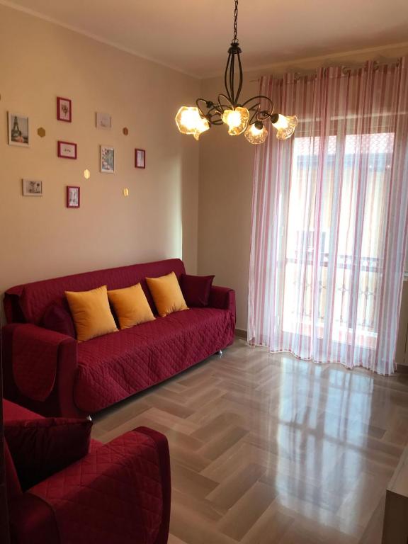 a living room with a red couch with yellow pillows at Residenza delle Rose in Lamezia Terme