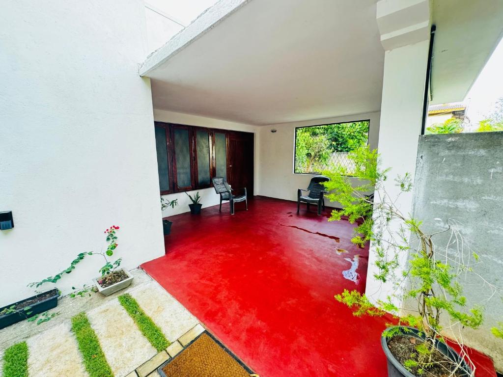 una sala de estar con suelo de color rojo en una casa en Prestiva Stay, en Anuradhapura